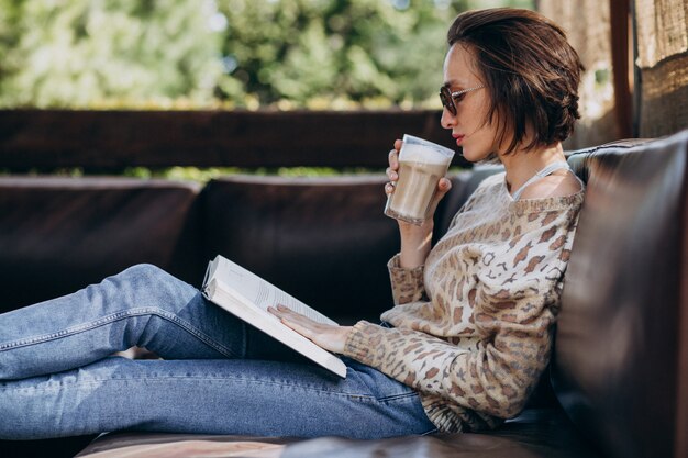 Photo gratuite jeune femme lisant un livre et buvant du café