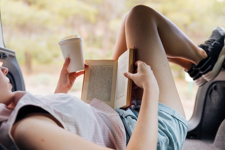 Photo gratuit jeune femme lisant un livre sur le repos