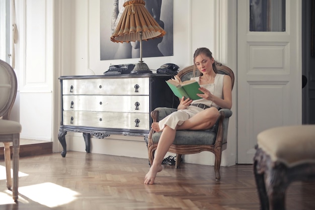 jeune femme lit un livre à la maison