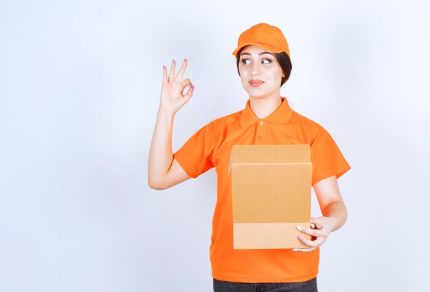 Jeune femme de livraison sur mur blanc