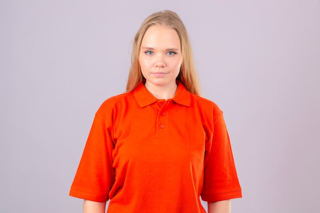Jeune femme de livraison en polo orange à la confiance avec le sourire sur le visage debout sur fond blanc isolé