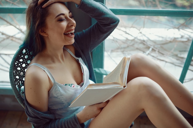 Jeune femme, livre lecture, séance, près, fenêtre