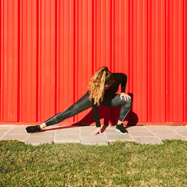 Jeune femme, longe, près, mur rouge