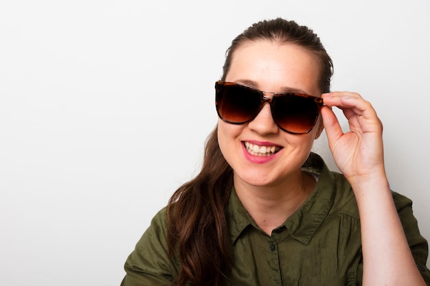 Jeune femme avec des lunettes de soleil souriant