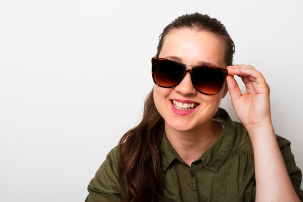 Jeune femme avec des lunettes de soleil souriant