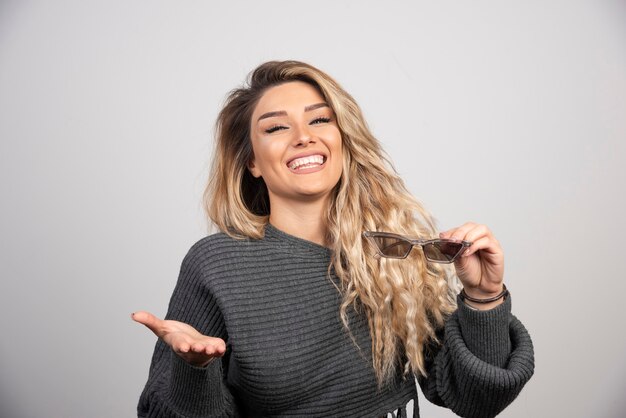 Jeune femme avec des lunettes souriant joyeusement.