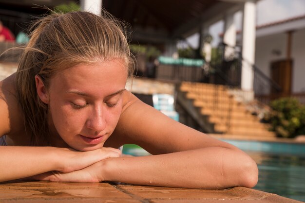 Jeune femme en maillot de bain près de la piscine