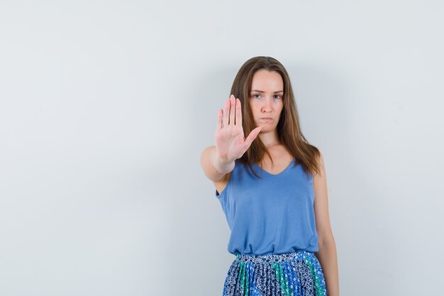 Jeune femme en maillot, jupe montrant le geste d'arrêt et à la stricte