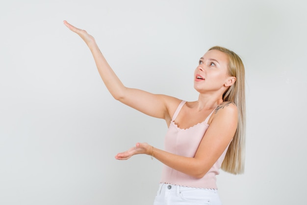 Jeune femme en maillot, mini jupe montrant la hauteur de quelque chose