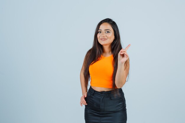 Jeune femme en maillot, mini jupe pointant vers le haut et jolie vue de face.