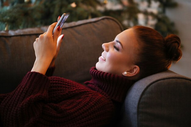 Jeune femme à la maison avec décoration de Noël