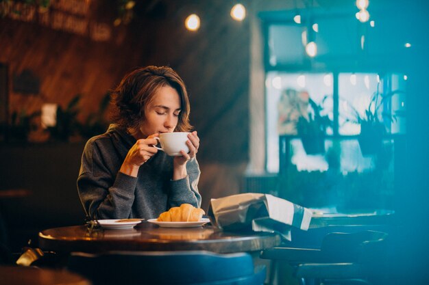 Jeune, femme, manger, croissants, café