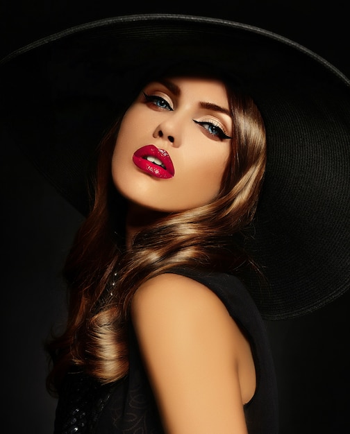 Jeune femme avec maquillage lumineux et chapeau noir