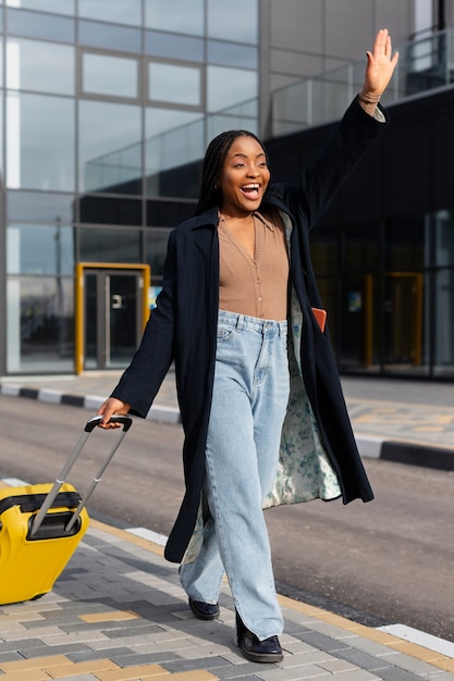 Jeune femme marchant avec des bagages plein coup