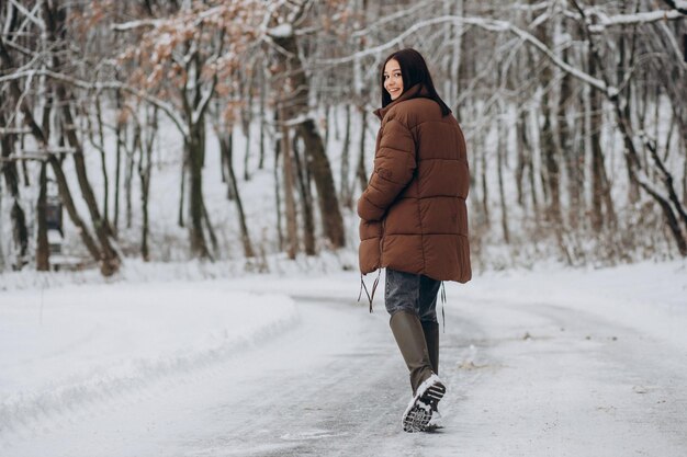 Jeune femme marchant dans le parc d'hiver