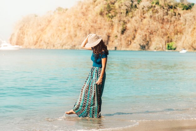 Jeune femme marchant le long de la plage déserte