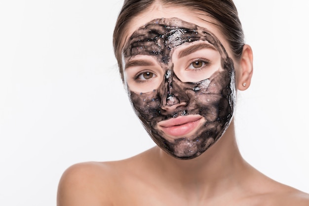 Jeune femme avec un masque noir purifiant sur son visage isolé sur mur blanc