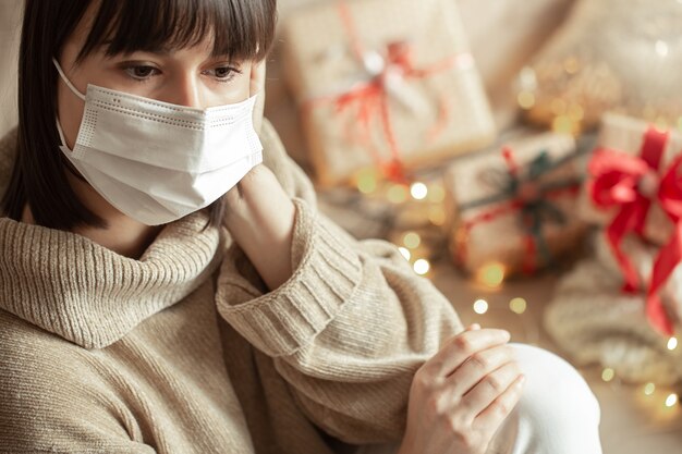 Jeune femme avec masque sur son visage dans un pull beige confortable