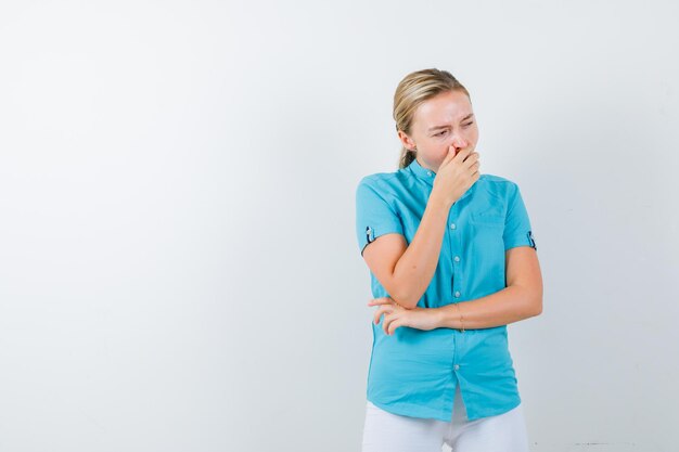 Jeune femme médecin bâillant en uniforme médical, masque et somnolent