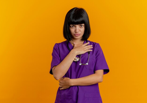 Jeune femme médecin brune agacée en uniforme avec stéthoscope