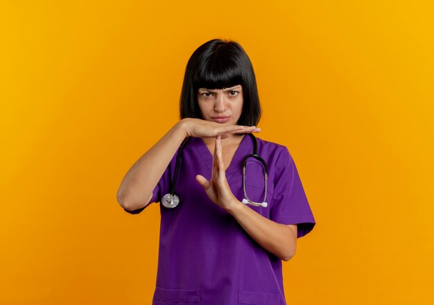 Jeune femme médecin brune mécontente en uniforme avec stéthoscope time out signe de la main