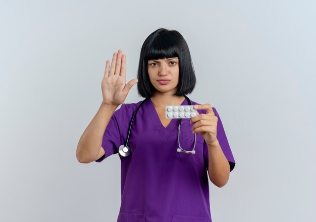 Jeune femme médecin brune sérieuse en uniforme avec stéthoscope