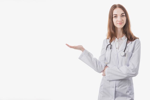 Photo gratuite jeune femme médecin montrant sur le côté