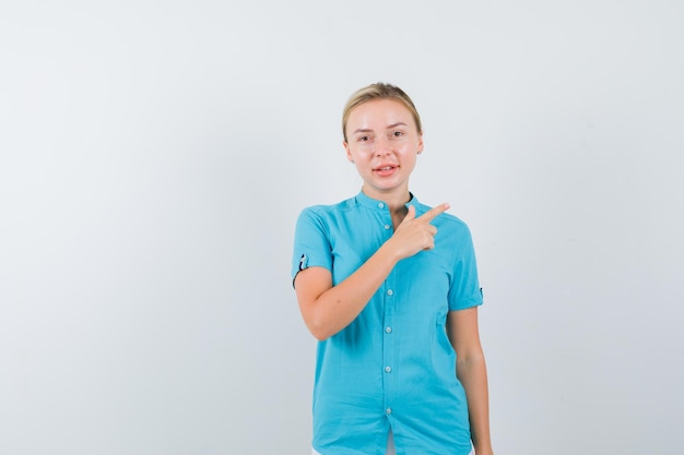 Jeune femme médecin pointant vers le coin supérieur droit en uniforme médical