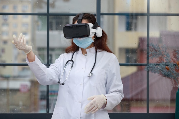 Jeune femme médecin portant des lunettes VR et levant la main Photo de haute qualité