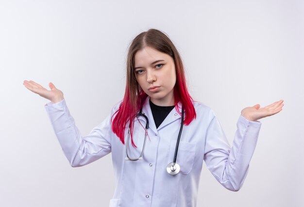 Jeune femme médecin portant une robe médicale stéthoscope étend les mains sur un mur blanc isolé