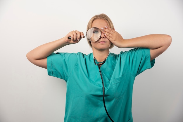 Jeune femme médecin avec stéthoscope et loupe.