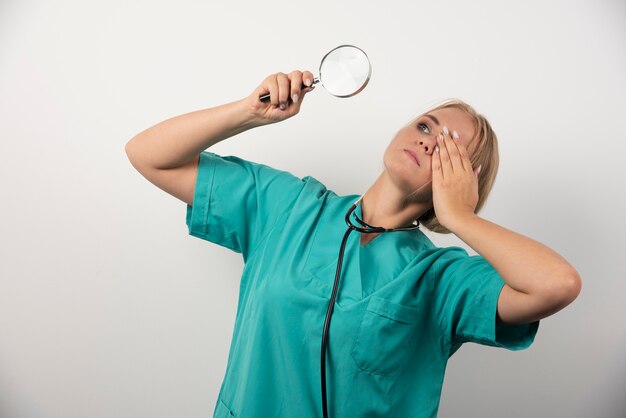 Jeune femme médecin avec stéthoscope et loupe.