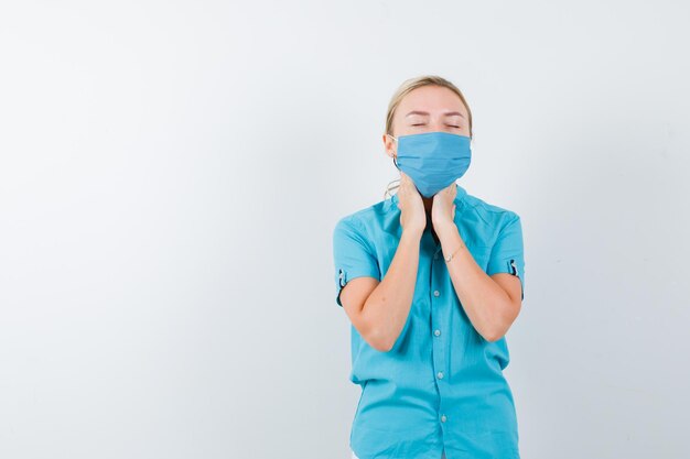 Jeune femme médecin tenant la main sur le cou en uniforme et l'air fatigué