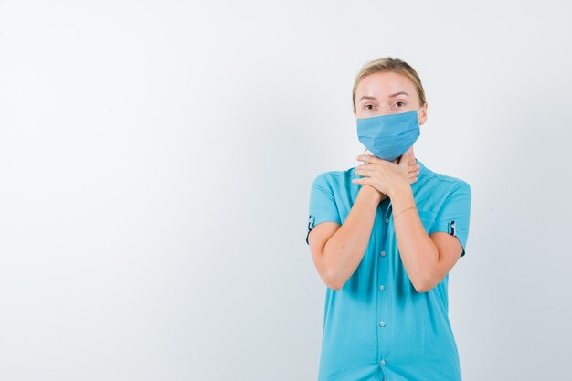 Jeune femme médecin en uniforme tenant la main sur la gorge et à la recherche de malaise isolé