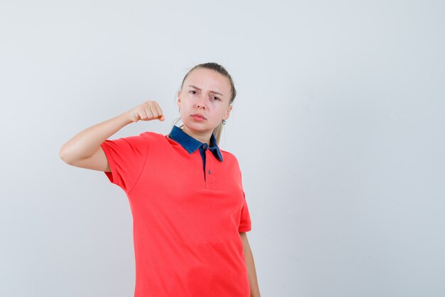 Jeune femme menaçant de poing en t-shirt et à la forte