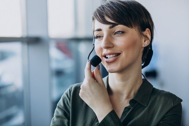 Jeune femme avec microphone travaillant sur studio d'enregistrement