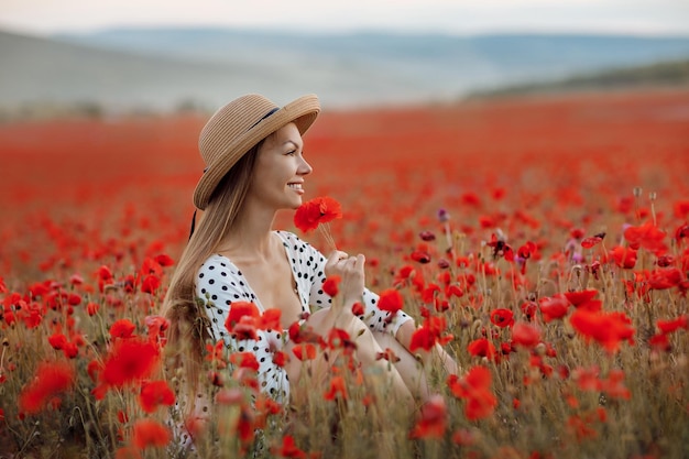 Jeune femme mignonne dans un champ de pavot