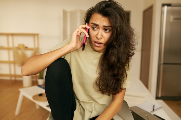 Jeune femme mignonne posant à l'intérieur