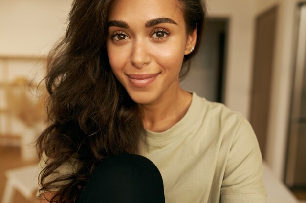 Jeune femme mignonne posant à l'intérieur