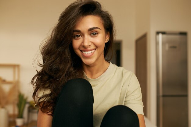 Jeune femme mignonne posant à l'intérieur