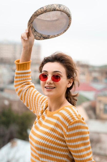 Une jeune femme mignonne tenant une casquette et posant à l'extérieur. photo de haute qualité