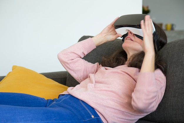 Jeune femme moderne en regardant une vidéo sur simulateur de réalité virtuelle