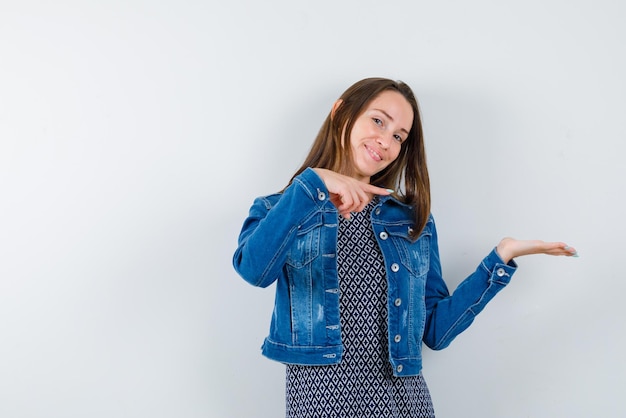 Jeune femme montrant le droit avec ses doigts et ses mains sur fond blanc