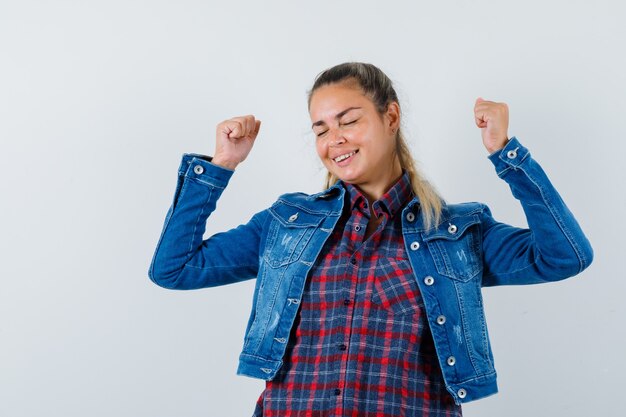 Photo gratuite jeune femme montrant le geste du gagnant en chemise, veste et à la béatitude, vue de face.