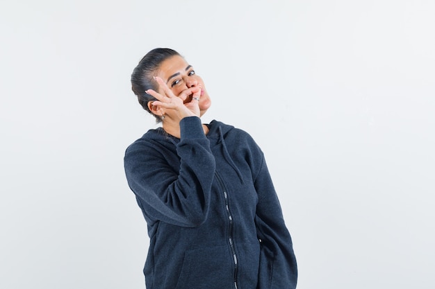 Jeune Femme Montrant Le Geste De Fermeture éclair En Veste Et à La Recherche De Secret. Vue De Face.