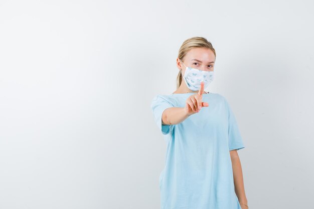 Jeune femme montrant un geste minute en t-shirt isolé