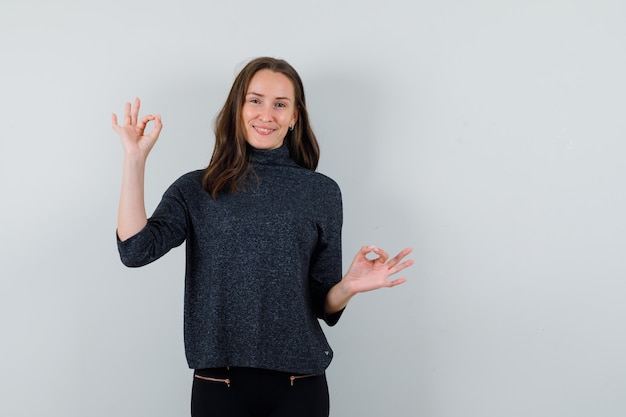 Jeune femme montrant un geste ok en chemise décontractée et à la recherche de joie. vue de face.