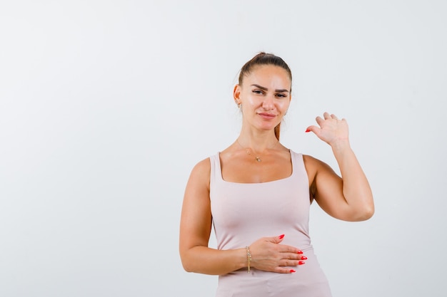 Photo gratuite jeune femme montrant la paume en singulet et à la confiance. vue de face.