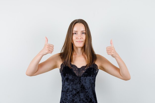 Jeune femme montrant les pouces vers le haut en maillot noir et à la satisfaction