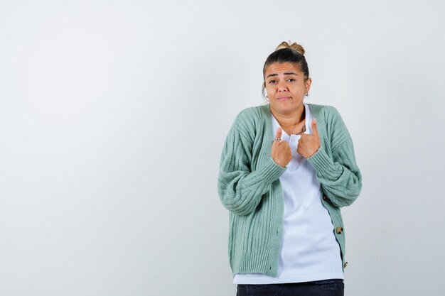 Jeune femme montrant les pouces vers le haut en t-shirt, veste et à l'air confiant